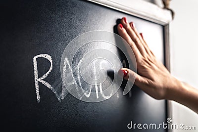 Racism concept. Stop hate and discrimination. Against prejudice and violence. Hand wiping off and erasing the word. Stock Photo