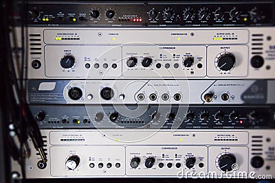 A rack of audio compressors in a recording studio Stock Photo