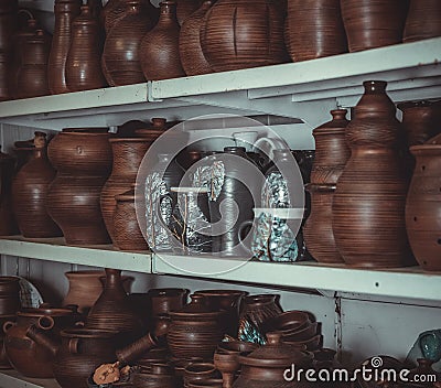 Racks in a pottery workshop with pottery, many different pottery standing on the shelves in a potery workshop Stock Photo