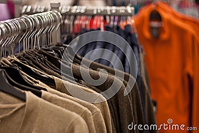 Racks of sweaters and shirts hanging in a store Stock Photo