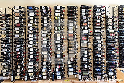 Radda in Chianti, Italy - April 20, 2018: Holder with wine bottles. Showcase wine shop. Wall with wine bottles. A variety of wine Editorial Stock Photo