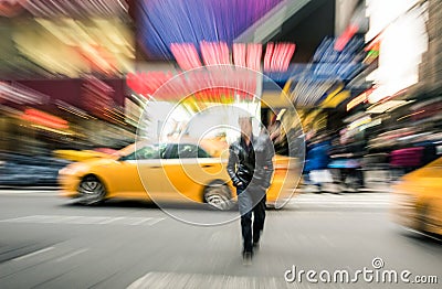 Radial blur of yellow taxicabs and unidentified person in New York City Editorial Stock Photo