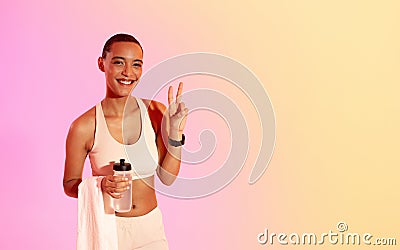 Radiant fitness enthusiast showing a peace sign while holding a water bottle Stock Photo