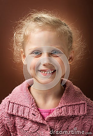 Radiant smile of little blond girl on dark Stock Photo