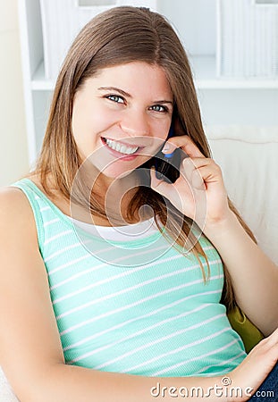 Radiant woman talking on phone sitting on a sofa Stock Photo