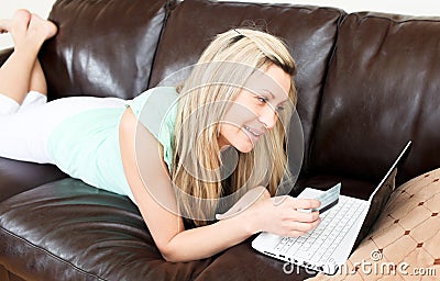 Radiant young woman using her laptop on the sofa Stock Photo
