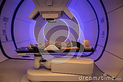 Radiation proton therapy. Brain cancer child patient lying on positioning bed with fixing mask on her head Stock Photo