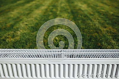 Radiator on green lawn, ecological heating concept Stock Photo