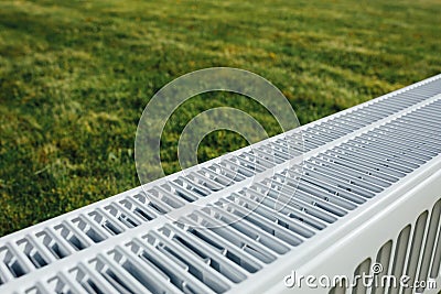 Radiator on green lawn, ecological heating concept Stock Photo