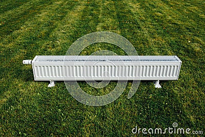 Radiator on green lawn, ecological heating concept Stock Photo