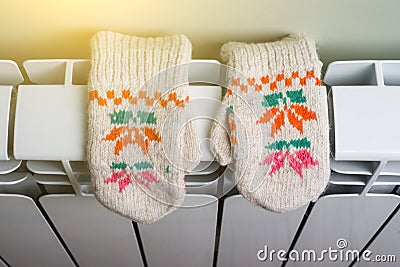 Radiator heating panel with knitted baby mittens Stock Photo