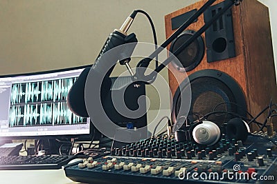 Radio microphone, mixing console and headphones on the background of the monitor Stock Photo