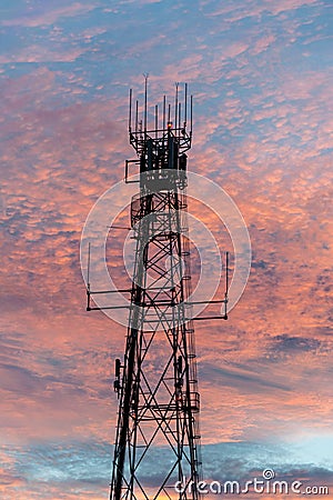 Radio and television broadcasting communications tower in Lightning Ridge back lit by a pink sunset Stock Photo