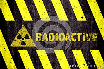 Radioactive ionizing radiation danger symbol and word with yellow and black stripes painted on a massive concrete wall Stock Photo