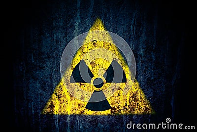 Radioactive ionizing radiation nuclear danger yellow symbol on massive cracked concrete wall dark rustic grunge background Stock Photo