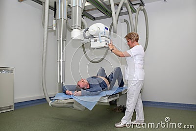 Radiologists Performing X-ray On Patient. Technician Setting Up Machine To X-ray Patient. Editorial Stock Photo