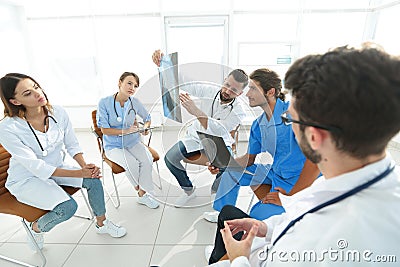 Radiologists and a surgeon discussing a radiograph of a patient Stock Photo