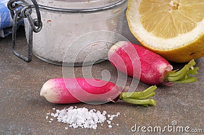 Radish next to fleur de sel and a lemon close-up on a gray background Stock Photo