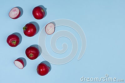 Radish with shadow on blue backdrop as border, top view. Modern color vegetable background. Stock Photo