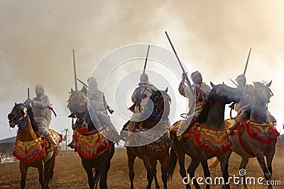 Raditionally dressed Moroccan tribals and horsemen riding the horses and fire the rifles Editorial Stock Photo