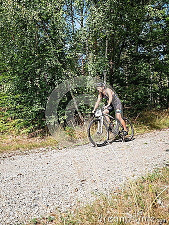 Middle age sportsman downhill ride from forest on silver bike Editorial Stock Photo