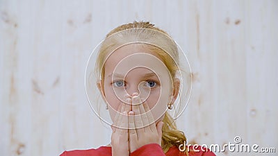 Ragazza con la paura di un ritratto che chiude la faccia a mani nello studio della luce La ragazza che ha paura di guardare la te stock footage Ragazza con la paura di un ritratto che chiude la faccia a mani nello studio della luce La ragazza che ha paura di guardare la te stock footage