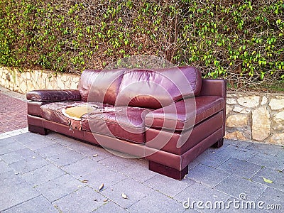 Ragged leather sofa dumped on a street Stock Photo