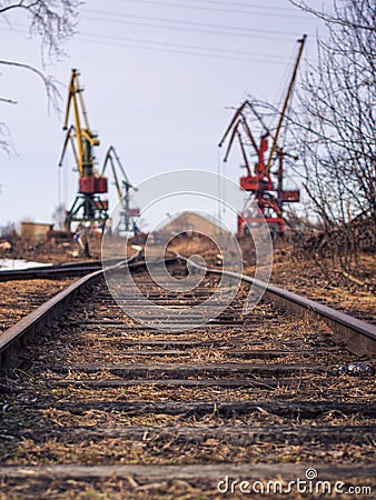 Rail road tracks under the gantry cranes on the berth of sea merchant port Stock Photo