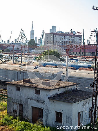 Railroad in the city. Abandoned scrap. Port cranes and high-rise buildings. Many railway paths. Wagons and trains on the tracks. Editorial Stock Photo