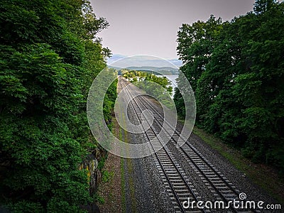 Railroad going through the forest to the hills and sky. Stock Photo