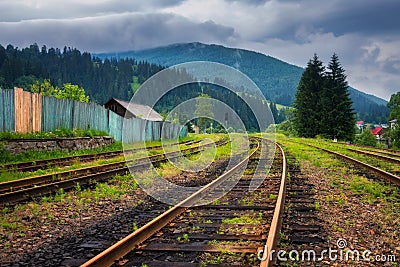 Railroad in mountains in overcast summer day Stock Photo