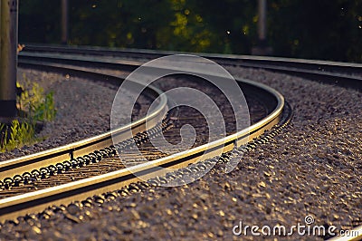 Railroad tracks lit by golden sunset light Stock Photo