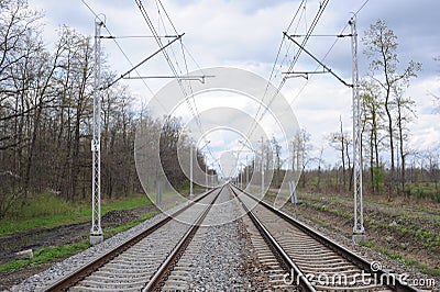 Railroad tracks for trains with steel rails and gravel creating straight perspective lines till horizon Stock Photo