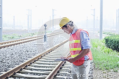 Railroad worker in protective work wear checking the railroad tracks Stock Photo