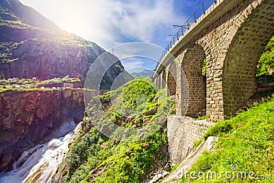 Railway bridge Teufelsbrucke over Reuss river in St. Gotthard mountain range of Swiss Alps near Andermatt Stock Photo