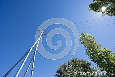 Railway catenary against a blue sky and sun Stock Photo