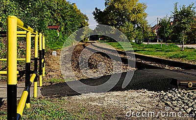 railway pedestrian crossing with yellow and black striped steel tube railing Stock Photo