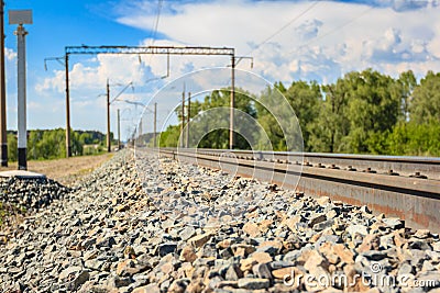 Railway rails in rural areas, passing through the forest. Beautiful sky with clouds. Siberian urban landscape Stock Photo