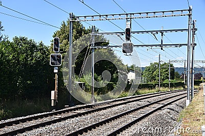 Railway track with overhead line equipment made of posts, catenaries, wires and power lines to supply trains. Stock Photo