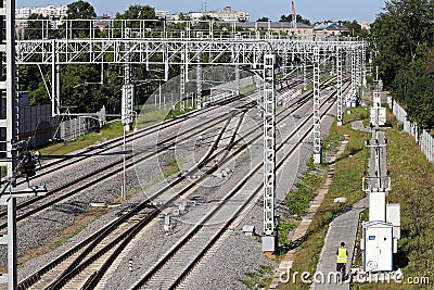 Railway tracks go into the distance. Railway power lines. Lines, diagonals, rhythm. City. Industrial landscape. Stock Photo