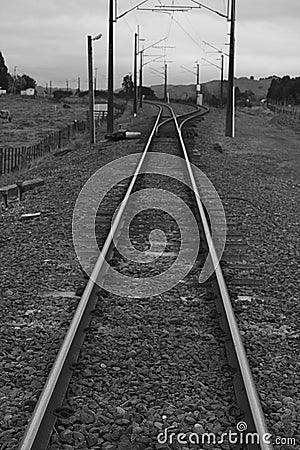 Railway tracks running beneath power lines Stock Photo