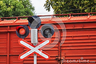 Railway traffic light against the background of a red freight car. Red prohibition light is on. The concept of an Stock Photo
