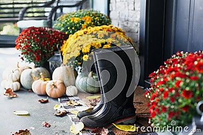 Rain Boots on Front Porch Decorated for Autumn Stock Photo