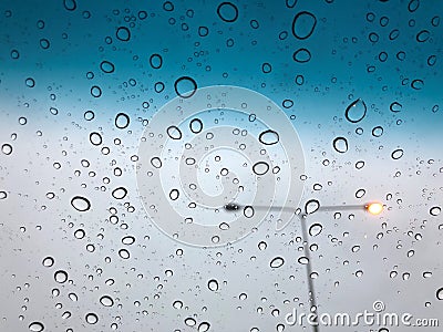 Rain drops on the car sunroof with lamp pole on the street backdrop Stock Photo