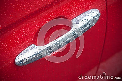 Rain drops on metallic handle on red car Stock Photo