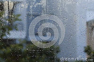 Rain drops on window with gray and green blurs Stock Photo