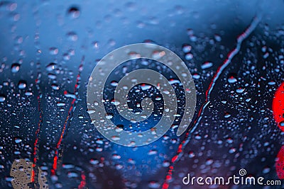 Rain drops on window with road light bokeh, rainy season. Stock Photo