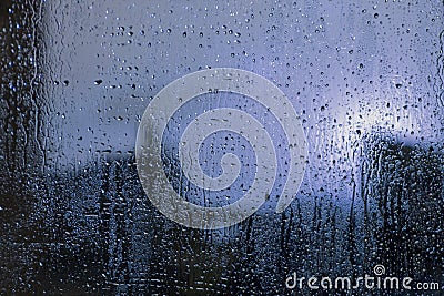 Rain drops on window with view of dark street Stock Photo
