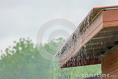 Rain flowing down from the roof house Stock Photo