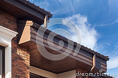 Rain gutter on a modern brick house with plastic windows. Stock Photo